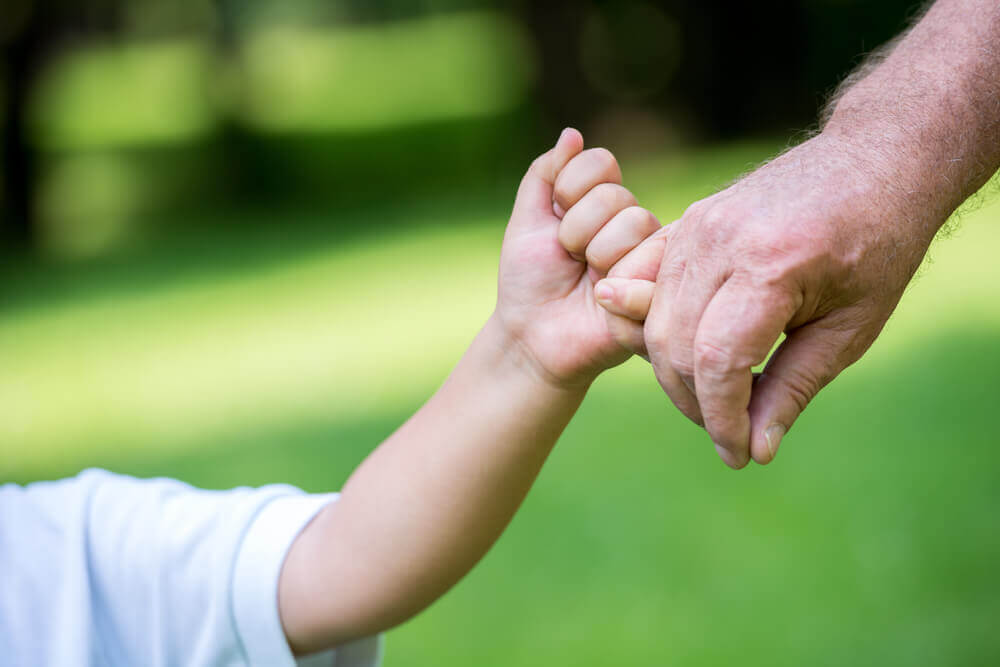 Grandfather and child are holding hands
